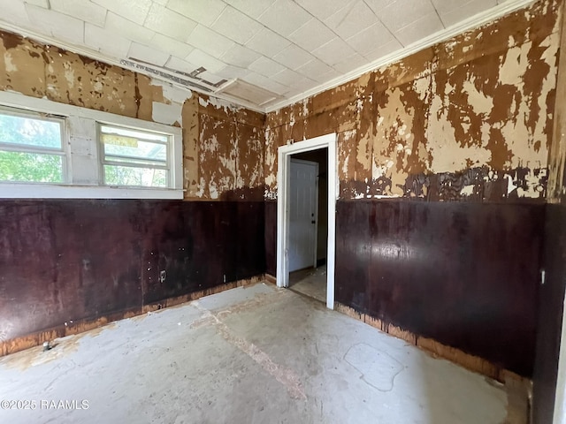 617 E Madison St, Opelousas, LA 70570 - spare room with unfinished concrete floors, wainscoting, ornamental molding, and wood walls