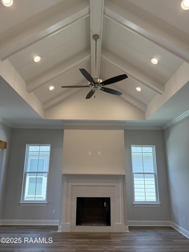 303 Bennington Ln, Youngsville, LA 70592 - detailed view of wood finished floors, baseboards, ceiling fan, beam ceiling, and a fireplace