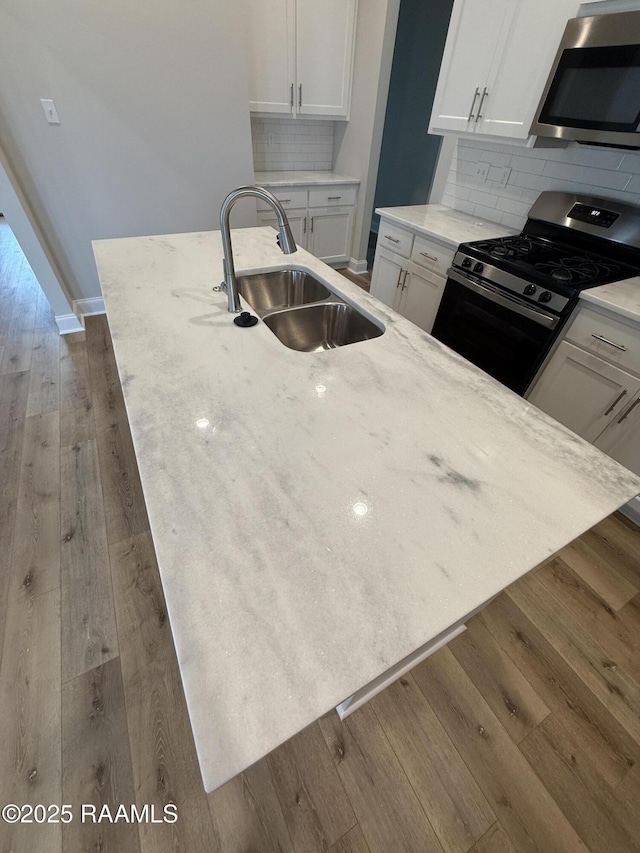 303 Bennington Ln, Youngsville, LA 70592 - kitchen with appliances with stainless steel finishes, a sink, white cabinetry, and dark wood finished floors