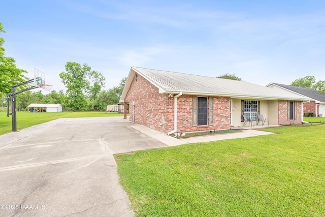 view of property exterior with a lawn, brick siding, and concrete driveway