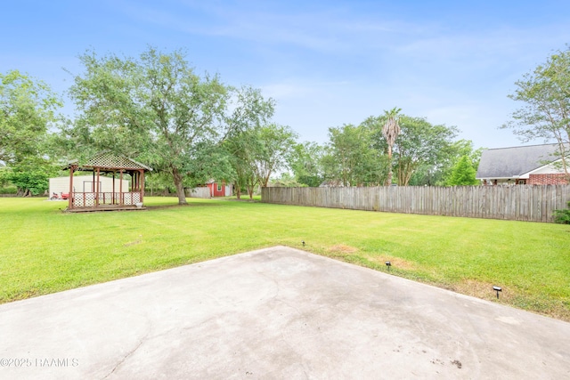 view of yard with a gazebo, a patio, a storage shed, and an outbuilding