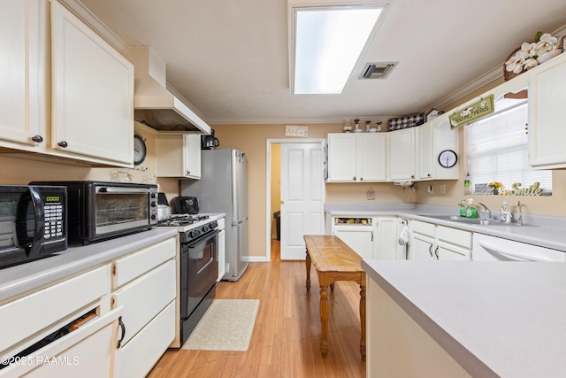 kitchen featuring range with gas cooktop, white cabinetry, dishwasher, light countertops, and black microwave