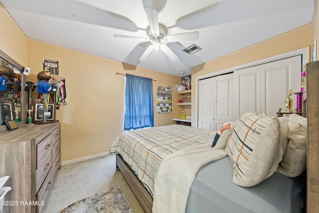 bedroom featuring light colored carpet, a closet, baseboards, and ceiling fan