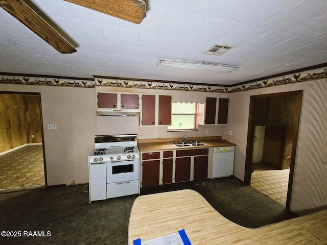 kitchen with white appliances, under cabinet range hood, a sink, and dark floors