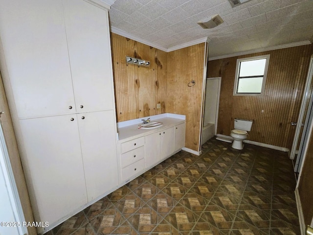 full bath featuring wooden walls, ornamental molding, toilet, vanity, and  shower combination