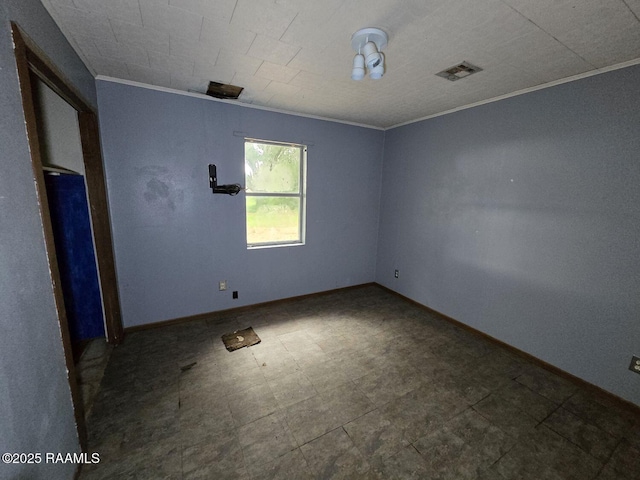 empty room with crown molding and baseboards