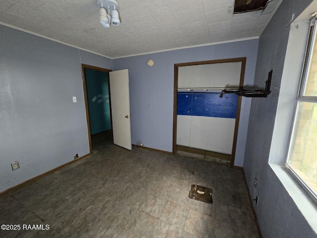 unfurnished room with ornamental molding and baseboards