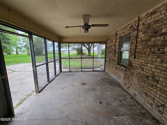 unfurnished sunroom featuring a ceiling fan