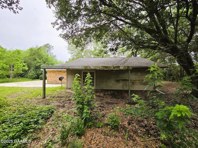 view of property exterior featuring driveway and an attached carport