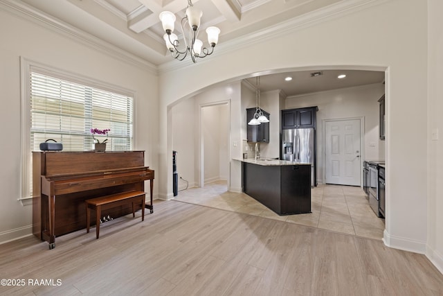 113 Gilmore Rd, Youngsville, LA 70592 - kitchen featuring arched walkways, a chandelier, a peninsula, stainless steel refrigerator with ice dispenser, and ornamental molding