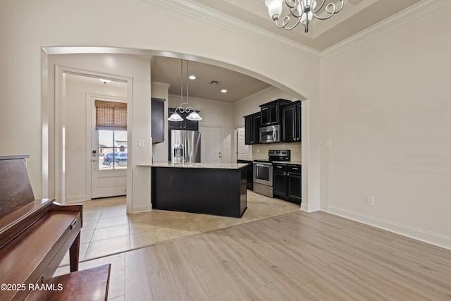 113 Gilmore Rd, Youngsville, LA 70592 - kitchen with stainless steel appliances, dark cabinetry, a chandelier, crown molding, and light wood-type flooring