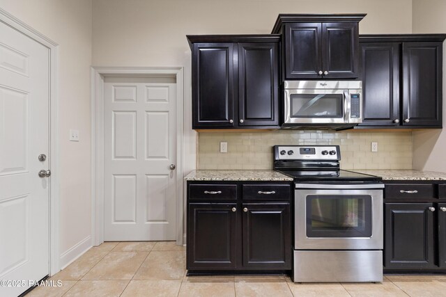 113 Gilmore Rd, Youngsville, LA 70592 - kitchen with stainless steel appliances, dark cabinetry, and decorative backsplash