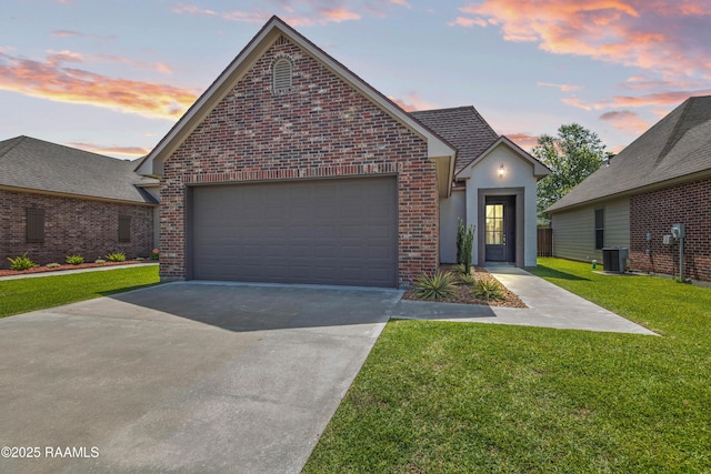 113 Gilmore Rd, Youngsville, LA 70592 - view of front facade featuring brick siding, a garage, a front lawn, driveway, and central AC unit
