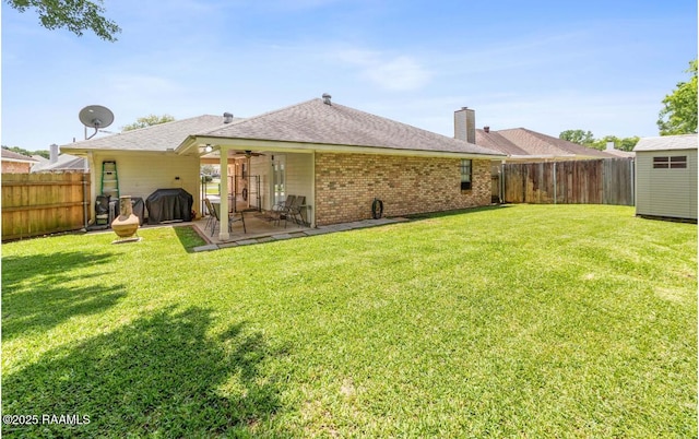 211 Dartmoor Dr, Lafayette, LA 70506 - rear view of house featuring brick siding, a patio, a chimney, ceiling fan, and an outdoor structure