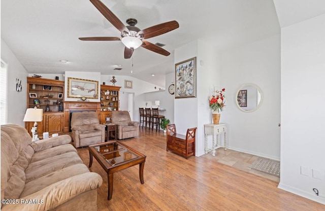 211 Dartmoor Dr, Lafayette, LA 70506 - living area featuring vaulted ceiling, a ceiling fan, light wood-style floors, and baseboards