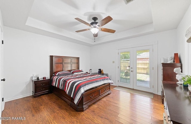 211 Dartmoor Dr, Lafayette, LA 70506 - bedroom with french doors, a tray ceiling, access to outside, wood finished floors, and ceiling fan