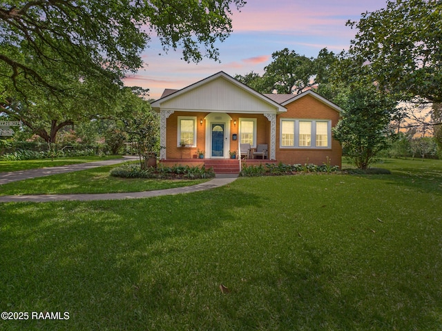 1635 Myrtle Pl, Lafayette, LA 70506 - bungalow-style home with covered porch, brick siding, and a front lawn