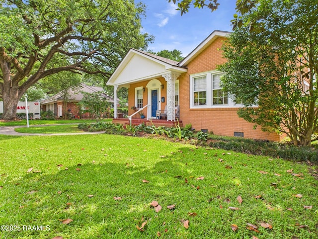 1635 Myrtle Pl, Lafayette, LA 70506 - view of front of house featuring brick siding, a front yard, and a porch