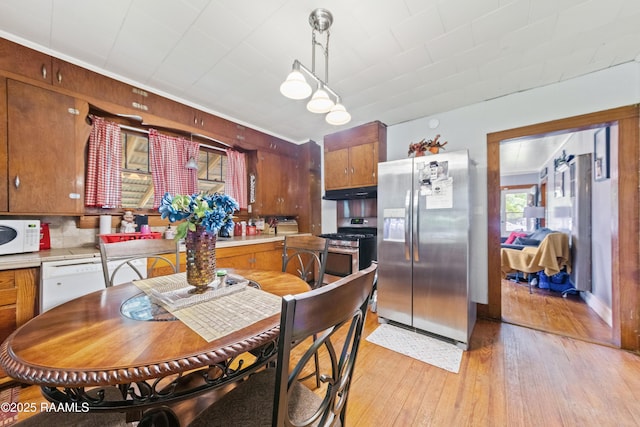 408 Loraine St, Abbeville, LA 70510 - kitchen with appliances with stainless steel finishes, light wood-style flooring, under cabinet range hood, light countertops, and brown cabinetry