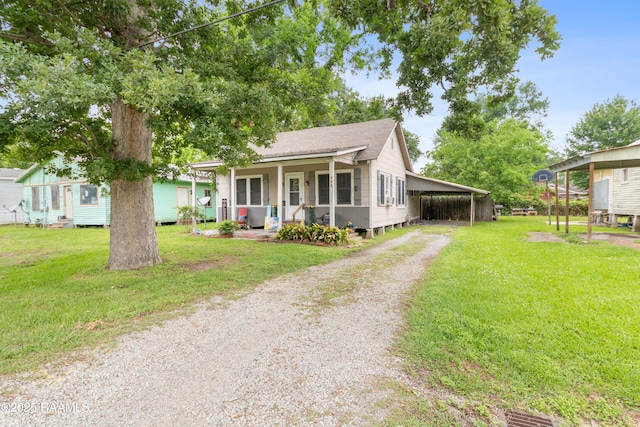 408 Loraine St, Abbeville, LA 70510 - view of front of house featuring driveway, a front lawn, a porch, a shingled roof, and a carport