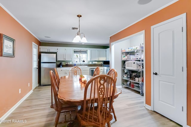 400 Mustang St, Lafayette, LA 70506 - dining area with crown molding, light wood-style floors, and baseboards