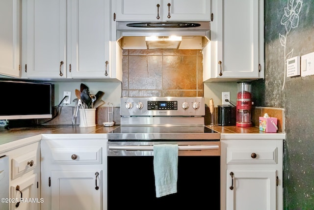 400 Mustang St, Lafayette, LA 70506 - kitchen featuring electric range, under cabinet range hood, white cabinetry, backsplash, and tile countertops