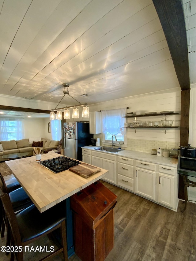 808 6th St, Rayne, LA 70578 - kitchen featuring a sink, freestanding refrigerator, stovetop, dark wood finished floors, and white cabinetry