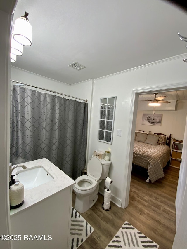 808 6th St, Rayne, LA 70578 - full bath with wood finished floors, toilet, vanity, and a shower with shower curtain