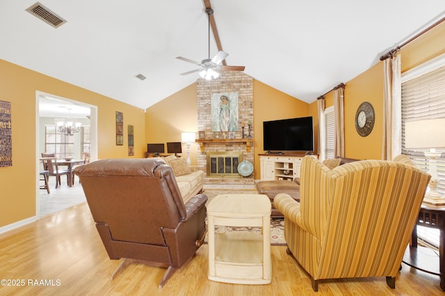 116 Twin Lakes Dr, Youngsville, LA 70592 - living room with ceiling fan, light wood-style floors, a chandelier, a fireplace, and lofted ceiling
