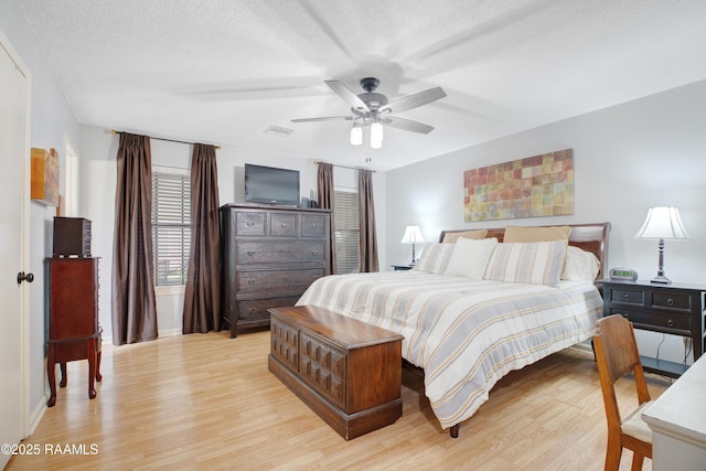 116 Twin Lakes Dr, Youngsville, LA 70592 - bedroom with light wood-style floors, baseboards, a textured ceiling, and ceiling fan