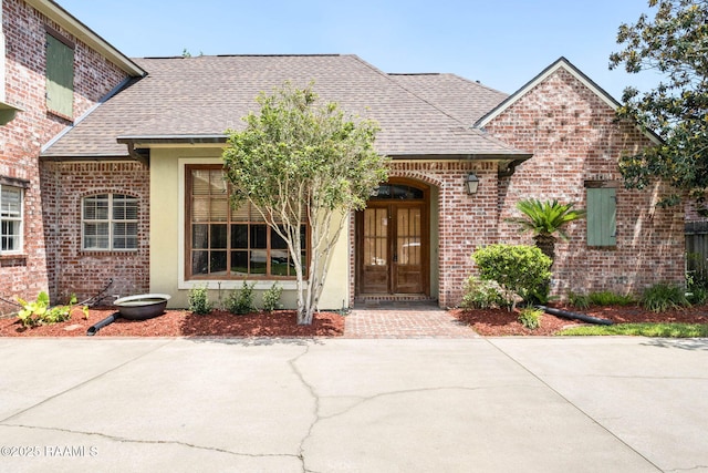 103 Barronne St, Lafayette, LA 70503 - view of front facade with brick siding, a shingled roof, and french doors