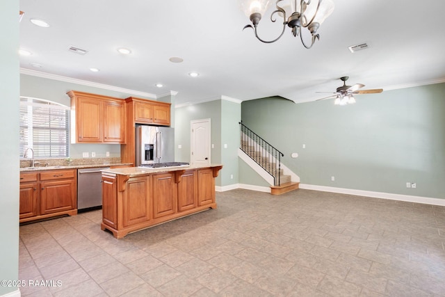 103 Barronne St, Lafayette, LA 70503 - kitchen with stainless steel appliances, crown molding, a sink, baseboards, and a kitchen island