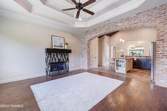 112 Heathwood Dr, Broussard, LA 70518 - living area featuring ornamental molding, a raised ceiling, dark wood finished floors, a ceiling fan, and arched walkways