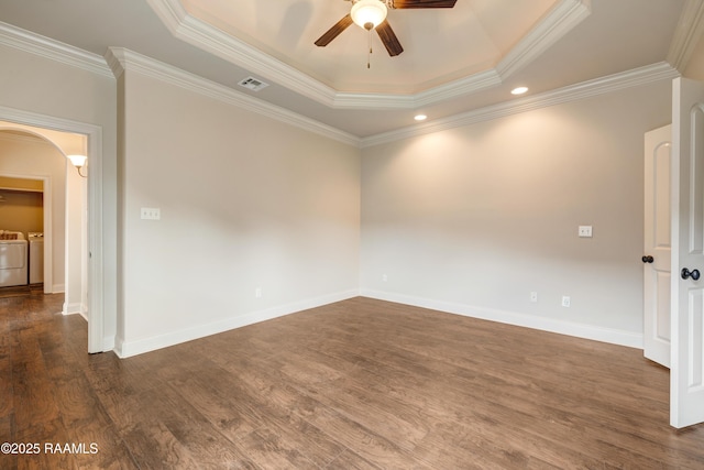 112 Heathwood Dr, Broussard, LA 70518 - spare room featuring independent washer and dryer, a ceiling fan, a tray ceiling, arched walkways, and dark wood-style flooring