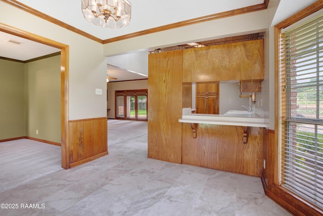 505 River Woods Dr, Lafayette, LA 70508 - kitchen featuring a kitchen breakfast bar, light countertops, a chandelier, crown molding, and a sink