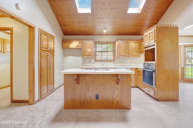 505 River Woods Dr, Lafayette, LA 70508 - kitchen with black oven, a skylight, a kitchen island, light countertops, and vaulted ceiling