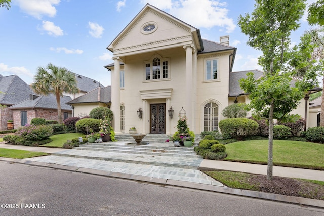 209 Princeton Woods Loop, Lafayette, LA 70508 - neoclassical / greek revival house featuring a chimney, a front lawn, stucco siding, and a shingled roof