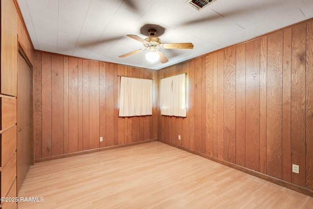 1341 College Rd, Eunice, LA 70535 - unfurnished room with wood finished floors, a ceiling fan, wooden walls, and baseboards