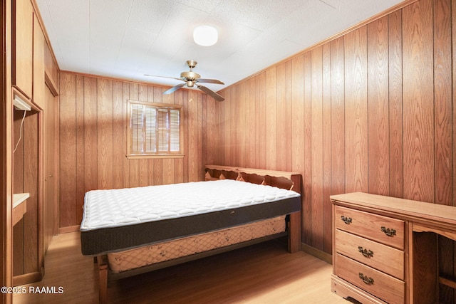1341 College Rd, Eunice, LA 70535 - bedroom featuring light wood-type flooring, wood walls, and a ceiling fan