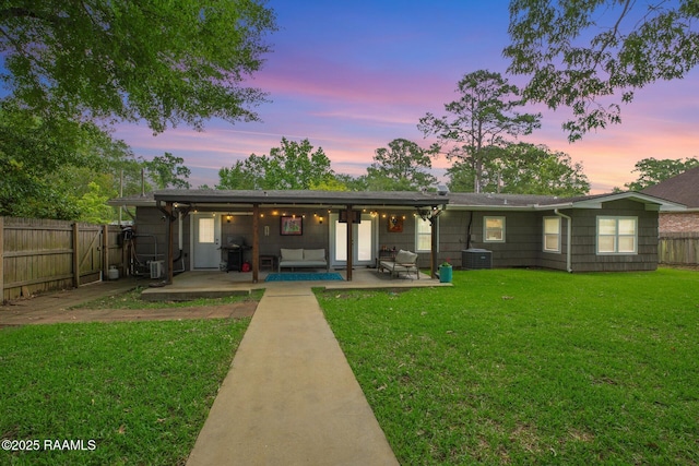 209 Irene Cir, Lafayette, LA 70503 - back of house at dusk with a patio area