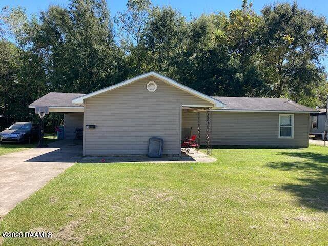 view of property exterior featuring driveway and a lawn