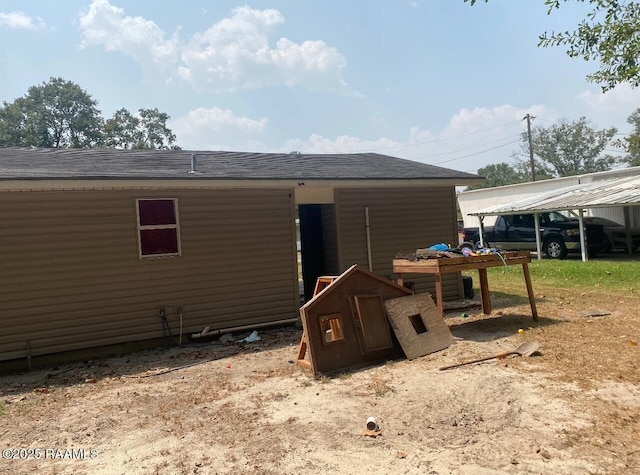 rear view of house with roof with shingles