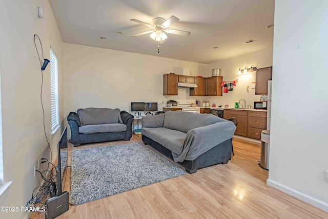 259 Chatrian St, Grand Coteau, LA 70541 - living room featuring ceiling fan, light wood finished floors, and baseboards