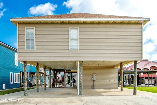 104 Trout Ct, Dulac, LA 70353 - rear view of house featuring a carport, concrete driveway, and a shingled roof