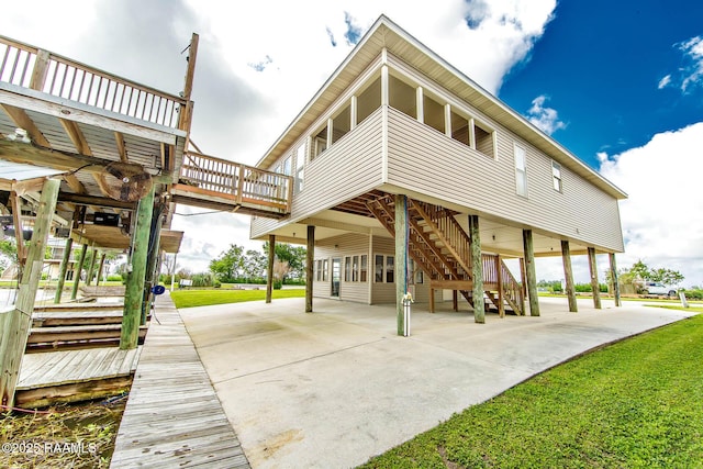 104 Trout Ct, Dulac, LA 70353 - back of property featuring stairway, a carport, driveway, and a deck