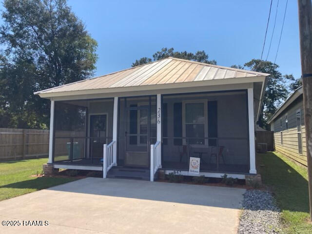 236 Chatrian St, Grand Coteau, LA 70541 - view of front of home with a standing seam roof, covered porch, and metal roof