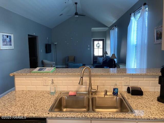 236 Chatrian St, Grand Coteau, LA 70541 - kitchen featuring a sink, open floor plan, ceiling fan, vaulted ceiling, and light stone countertops
