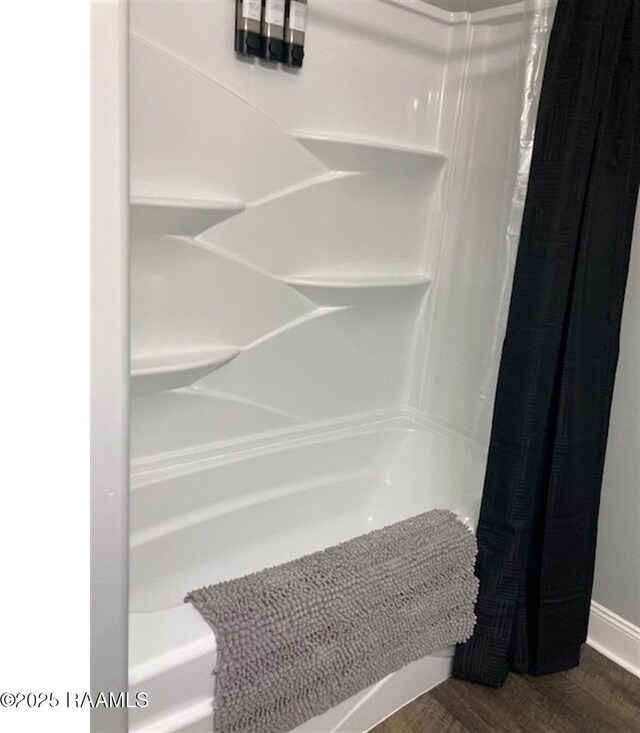 236 Chatrian St, Grand Coteau, LA 70541 - full bathroom featuring curtained shower, wood finished floors, and baseboards