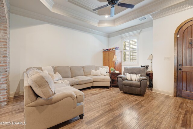 108 Autumnbrook Dr, Broussard, LA 70518 - living room featuring arched walkways, light wood finished floors, ornamental molding, ceiling fan, and a tray ceiling