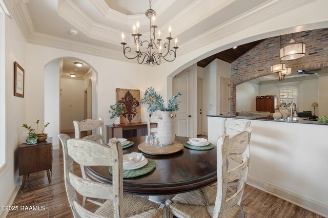 108 Autumnbrook Dr, Broussard, LA 70518 - dining room featuring arched walkways, a chandelier, wood finished floors, ornamental molding, and baseboards